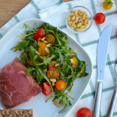 Mozzarella ukrytá v parmské šunce, rukolový salát s rajčátky a piniovými oříšky